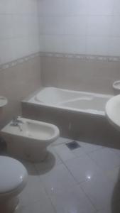 La salle de bains est pourvue d'une baignoire, de toilettes et d'un lavabo. dans l'établissement El Mahatta Building, à Charjah