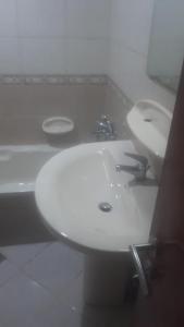 - une salle de bains pourvue de 2 lavabos blancs dans l'établissement El Mahatta Building, à Charjah