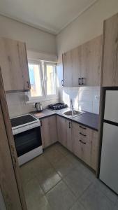 a kitchen with wooden cabinets and a stove and a sink at ΛΙΜΑΝΙ in Chios