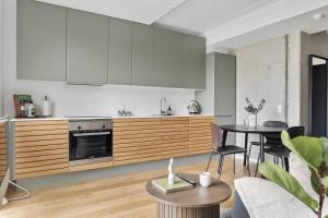 a kitchen with wooden cabinets and a table with chairs at Little luxury apartment in Aarhus