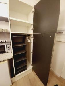 uma cozinha com um frigorífico preto em Le 29 cuty, wifi, à 3min de la gare sncf em Agen