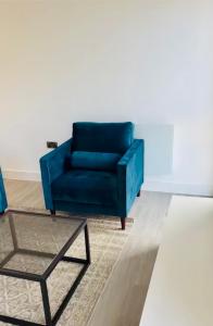 2 Bedroom Apartment In Kew Bridge في Kew Bridge: أريكة زرقاء وطاولة قهوة في غرفة المعيشة