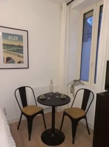uma pequena mesa e duas cadeiras num quarto em Le 29 cuty, wifi, à 3min de la gare sncf em Agen