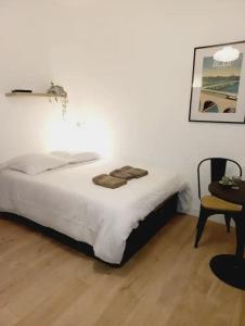 um quarto com uma cama, uma cadeira e uma mesa em Le 29 cuty, wifi, à 3min de la gare sncf em Agen