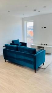 2 Bedroom Apartment In Kew Bridge في Kew Bridge: أريكة زرقاء موجودة في غرفة المعيشة