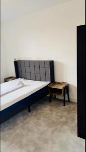 2 Bedroom Apartment In Kew Bridge في Kew Bridge: غرفة نوم بسرير وطاولة جانبية