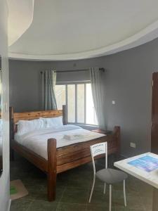 OLENG'OTI GARDENS في Narok: غرفة نوم بسرير وكرسي وطاولة