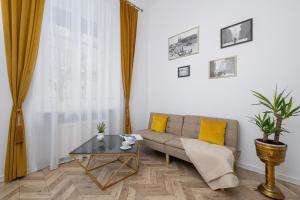 a living room with a couch and a table at Studio Apartment with Mezzanine near Kraków City Centre by Renters in Krakow