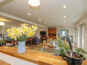 a kitchen and living room with yellow flowers on a table at The Pier House in Lochgilphead