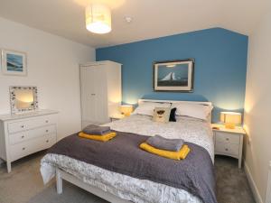 1 dormitorio con 1 cama grande y pared azul en The Pier House en Lochgilphead