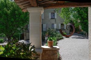 - une vue sur l'extérieur d'un bâtiment avec un pilier en pierre dans l'établissement Charembeau, à Forcalquier