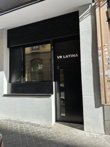 VR LATINA APARTMENTS في مدريد: مبنى مع علامة vvl latina على الباب