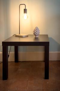 een tafel met een lamp en een plant erop bij Sikelia Luxury home in Catania