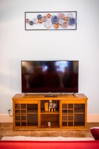 een flatscreen-tv bovenop een houten entertainmentcentrum bij Sikelia Luxury home in Catania