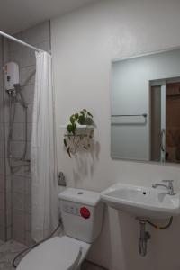 een witte badkamer met een toilet en een wastafel bij AboutTime Bangkok in Bangkok