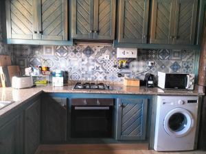 a kitchen with a stove and a washing machine at Quinta Do Marmeiral in Mangualde