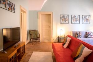 een woonkamer met een rode bank en een tv bij Sikelia Luxury home in Catania