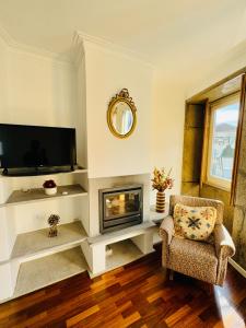 a living room with a fireplace and a television at Altamira Studio in Viana do Castelo