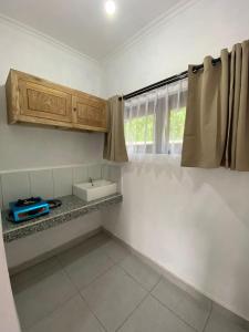 una pequeña cocina con fregadero y ventana en Candy home stay en Klungkung