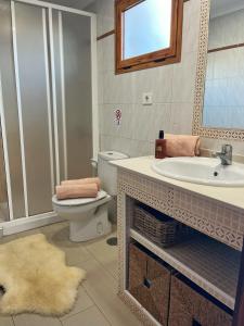 a bathroom with a toilet and a sink and a mirror at BuzzStays: 1-Bed Bungalow, Garden, Near Yumbo & Beach in Maspalomas