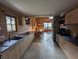 a large kitchen with wooden cabinets and a table at La Boutame : chalet au pied des pistes à Villard Reculas in Villard-Reculas