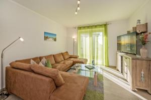 un soggiorno con un divano e una TV di Sonnenpark 02 a Korswandt