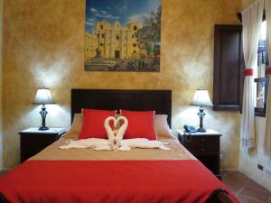 a bedroom with a bed with two swans on it at Casa Buena Vista in Antigua Guatemala