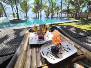 a table with a plate of food on it next to a pool at U Story Resort in Siquijor