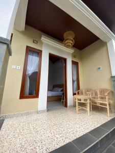 un porche de una casa con mesa y sillas en Candy home stay en Klungkung