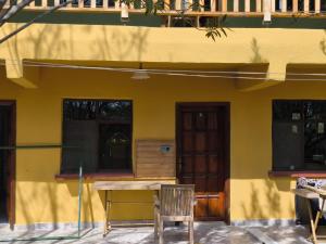 uma mesa e cadeiras em frente a um edifício amarelo em Fire Pansiyon em Cirali