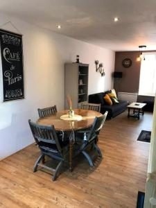 a living room with a table and chairs and a couch at Le franc 1949 in Toussaint