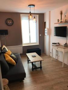 a living room with a couch and a coffee table at Le franc 1949 in Toussaint