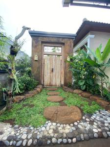 a door to a house with a walkway in front at Candy home stay in Klungkung