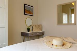 a hat sitting on a bed with a mirror at Casa Inzolia in Giardini Naxos