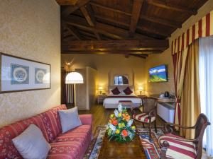 a living room with a couch and a bedroom at Hotel Orologio in Ferrara