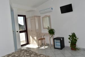 a bedroom with a bed and a tv and a chair at Hotel Quasar in Cala Liberotto