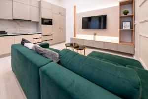 uma sala de estar com um sofá verde e uma cozinha em Opera residence (D10) em Budapeste