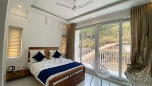 a bedroom with a bed and a balcony at Akai Vibe in Munnar