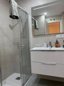 y baño con ducha y lavamanos. en El Encanto de la Playa Santa Mª Grupo AC Gestion en Cádiz