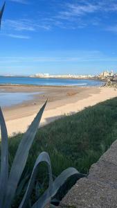 una playa con vistas al océano y a la playa en El Encanto de la Playa Santa Mª Grupo AC Gestion en Cádiz