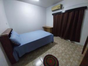 ein kleines Schlafzimmer mit einem Bett und einem Vorhang in der Unterkunft Chands Homestay Apartment in Lautoka