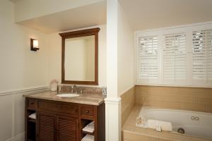 a bathroom with a sink, mirror, and bathtub at Lighthouse Lodge & Cottages in Pacific Grove