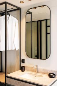 a bathroom with a sink and a mirror at Doryssa Lithos Hotel in Pythagoreio