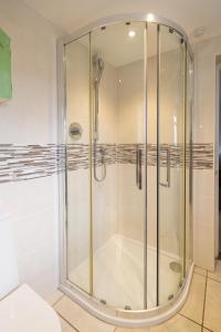 una ducha con mampara de cristal en un baño en Fishermans Loft - A seaside house in Thorpeness with direct access to the beach - Aldeburgh Coastal Cottages, en Thorpeness 28 fotos más