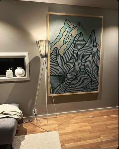 a room with a lamp and a painting on the wall at Strøken villa med spektakulær utsikt in Tromsø