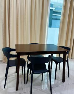 a dining room table with chairs and curtains at Fourteen Homestay in Port Dickson