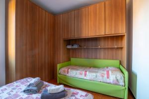 Schlafzimmer mit einem grünen Bett und Holzschränken in der Unterkunft Residenza Sabrina in Venedig