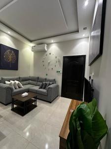 uma sala de estar com um sofá e uma televisão de ecrã plano em هابي رومز em Al Khobar
