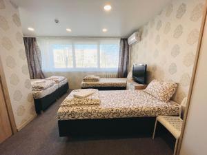 um pequeno quarto com duas camas e uma televisão em Savan House "Easy Kaunas" em Kaunas