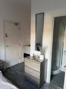 uma casa de banho com uma cómoda em madeira e um espelho em Abington Park 5 Bedrooms with en-suite em Spinney Hill